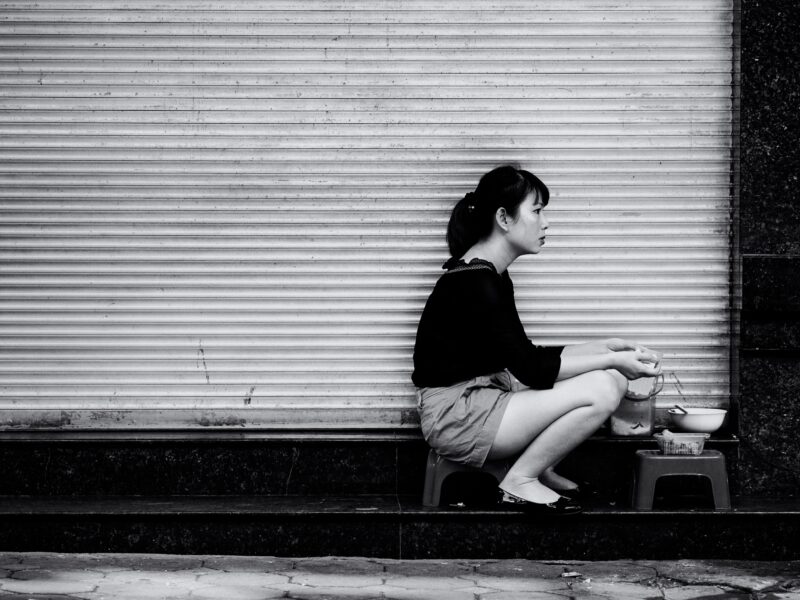 Morning soup person sitting eating soup on the side walk