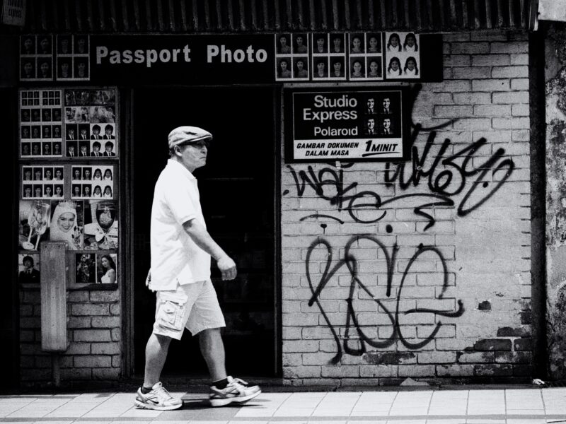 Passport photo Person walking past doorway that says passport photo